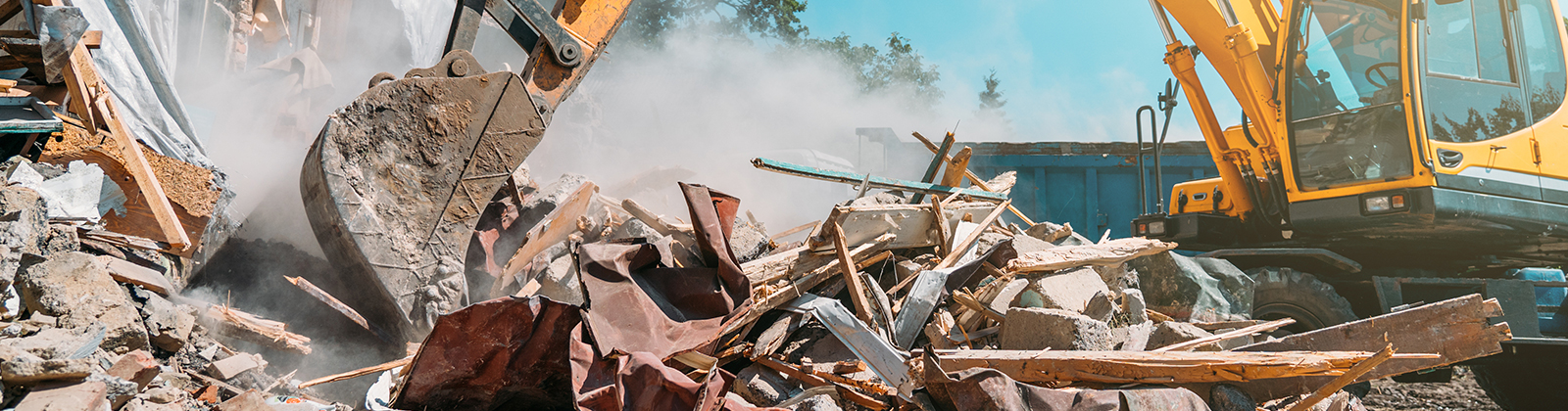 Demolition of building. Excavator breaks old house. Freeing up space for construction of new building.